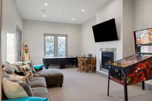 Living area with carpet, recessed lighting, and a glass covered fireplace