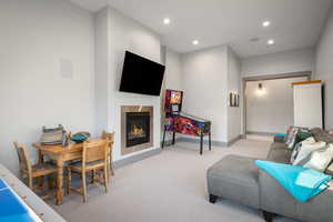 Carpeted living area featuring recessed lighting and a glass covered fireplace