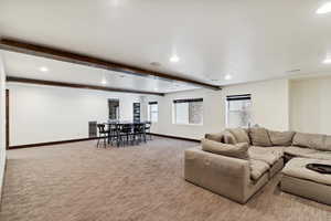 Living room with carpet, recessed lighting, and beamed ceiling