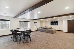 Carpeted dining space featuring beamed ceiling and recessed lighting