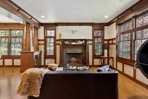 Living room featuring a fireplace, wood finished floors, healthy amount of natural light, ornamental molding, and recessed lighting
