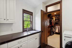 Washroom featuring cabinet space, washer / dryer, and dark carpet
