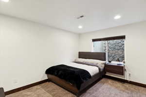 Carpeted bedroom with recessed lighting