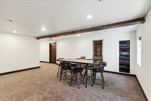 Dining space featuring recessed lighting, beamed ceiling, and light carpet