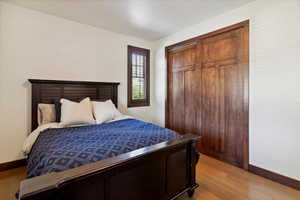 Bedroom with light wood-type flooring and a closet