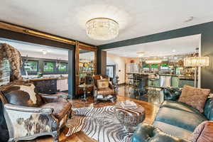 Living room featuring a chandelier, wood finished floors, and plenty of natural light