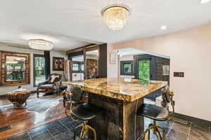 Bar area with recessed lighting, stone tile floors, and a chandelier
