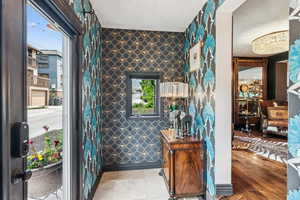 Foyer entrance featuring wallpapered walls