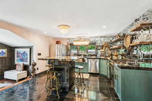 Kitchen with green cabinetry, stainless steel appliances, open shelves, recessed lighting, and a chandelier