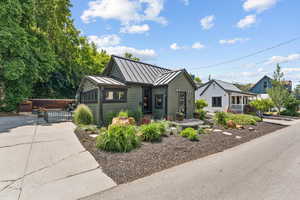 View of front of home with a standing seam roof, a gate, and a metal roof