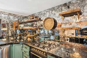 Kitchen with green cabinets, appliances with stainless steel finishes, and open shelves