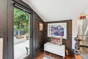 Doorway featuring lofted ceiling and wood finished floors