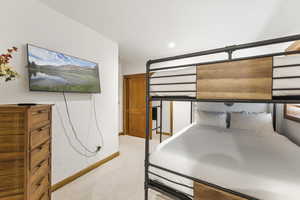Unfurnished bedroom featuring light carpet and baseboards