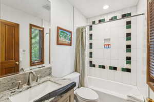 Bathroom featuring vanity and shower / bath combination with curtain