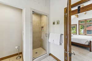 Bathroom with a stall shower, connected bathroom, and tile patterned floors