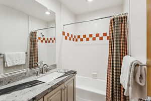 Bathroom featuring vanity, shower / tub combo, and recessed lighting