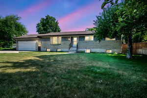 Ranch-style house featuring a garage, brick siding, and driveway
