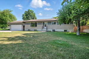 View of front of house with an attached garage and driveway