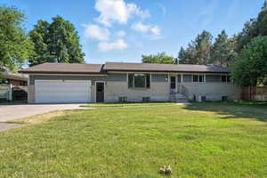 Ranch-style house with concrete driveway, a garage, and brick siding