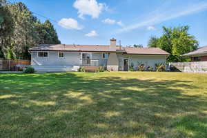 Rear view of property with a chimney and a wooden deck