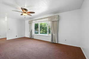 Unfurnished room with carpet floors and a ceiling fan