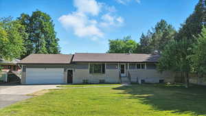 Ranch-style house featuring a garage, concrete driveway, and brick siding