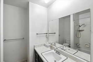 Bathroom with vanity, shower / tub combination, and a textured ceiling