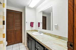 Full bathroom featuring a closet, vanity, and tile patterned floors