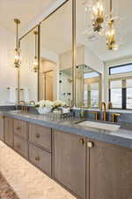 Full bath with a chandelier, double vanity, and a shower with shower door