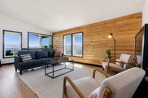 Living area featuring rustic walls, vaulted ceiling, and lake views