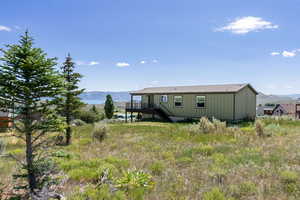 Rear view of property featuring stairs and a deck with mountain view