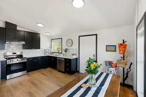 Kitchen featuring brand new stainless steel appliances, under cabinet range hood, quartz countertops, black cabinets