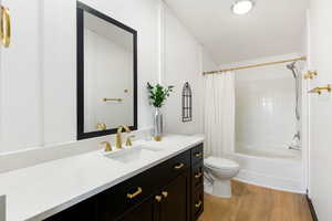 Master bathroom featuring LVP floors, vanity, and shower / tub combo and towel closet