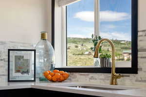 Kitchen view of tasteful backsplash and light stone countertops