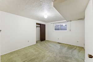 Unfurnished bedroom featuring carpet flooring, a closet, and a textured ceiling