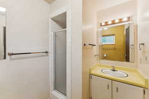 Full bathroom featuring a shower stall and vanity