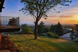 View of grassy yard featuring a wooden deck