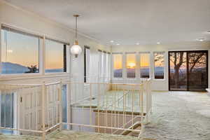 Hallway featuring carpet, ornamental molding, a textured ceiling, recessed lighting, and an upstairs landing