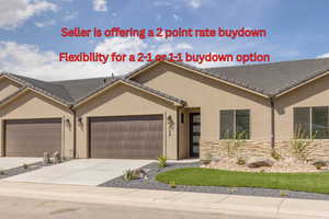 View of front facade featuring a garage, stucco siding, concrete driveway, and a tile roof