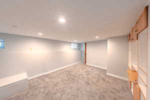 Below grade area featuring light colored carpet and recessed lighting