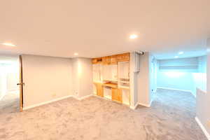 Finished below grade area featuring light carpet and recessed lighting