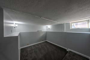 Carpeted spare room with baseboards and a textured ceiling