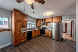 Kitchen featuring appliances with stainless steel finishes, open shelves, a textured ceiling, tasteful backsplash, and dark wood-style floors