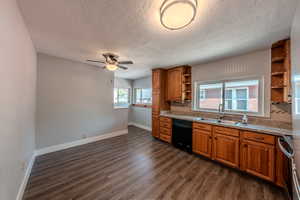 Kitchen with open shelves, dishwasher, a textured ceiling, range, and brown cabinetry