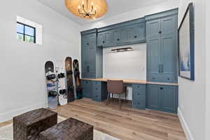 Office with a chandelier, light wood finished floors, and built in study area