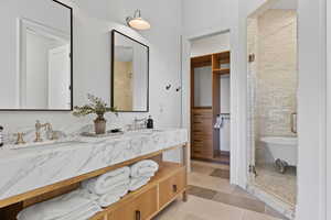 Full bathroom featuring double vanity and a stall shower