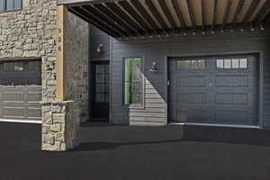 Entrance to property with stone siding and a garage