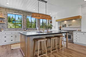Kitchen featuring double oven range, open shelves, white cabinetry, a kitchen island, and wood ceiling
