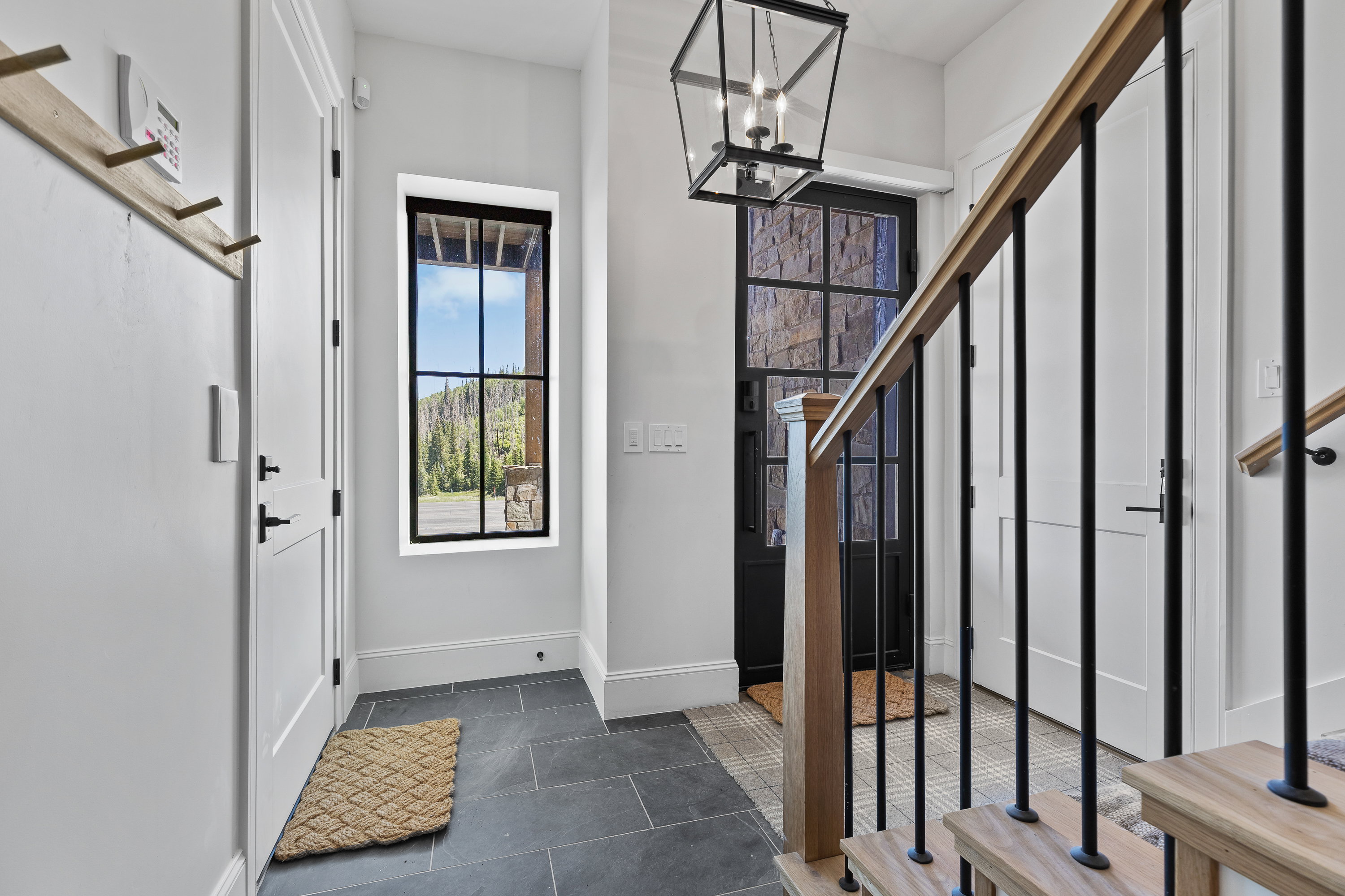 Foyer entrance featuring a chandelier and dark tile patterned floors