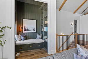 Living area featuring an upstairs landing, wood finished floors, and wooden ceiling